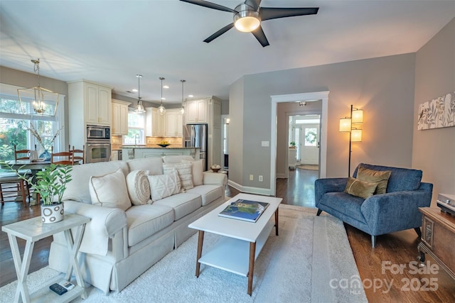 7409 Gilderstern Glen Ct, Huntersville, NC 28078 - living room featuring recessed lighting, baseboards, wood finished floors, and ceiling fan with notable chandelier