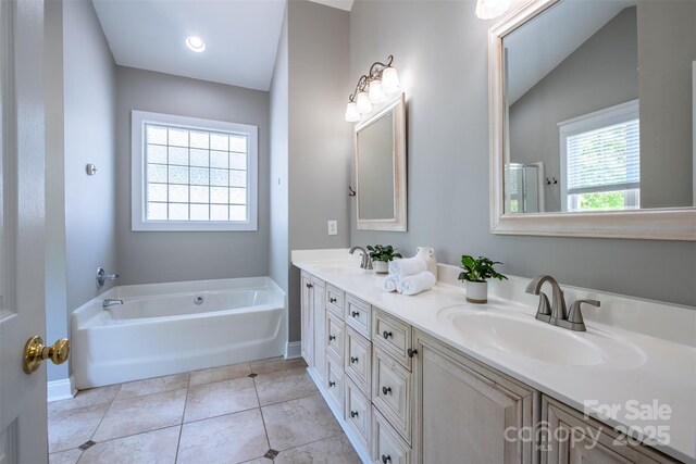 7409 Gilderstern Glen Ct, Huntersville, NC 28078 - full bathroom with a sink, baseboards, a garden tub, and double vanity