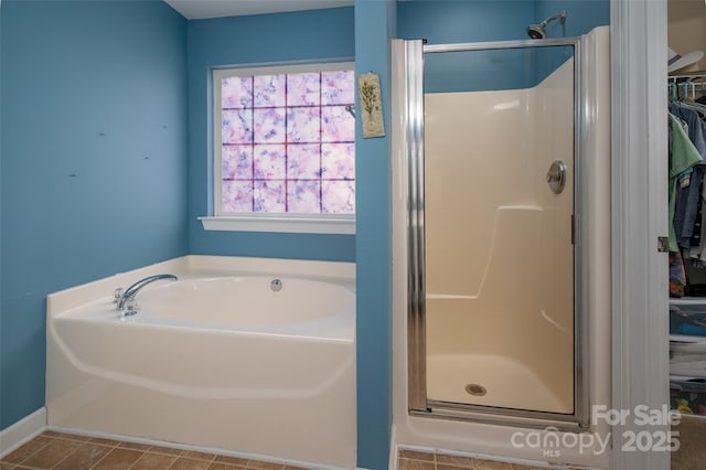 bathroom featuring a shower stall, a bath, and a spacious closet