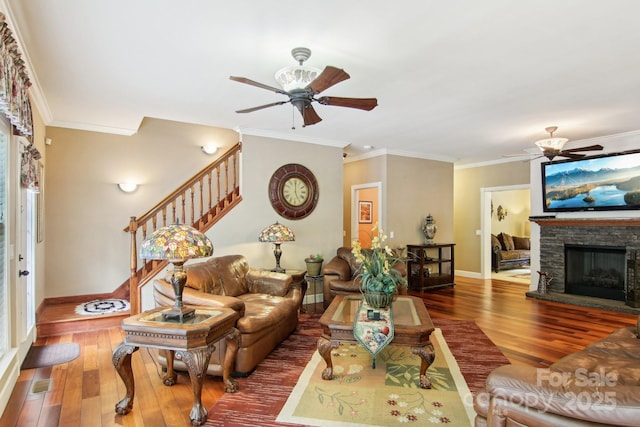 living area featuring stairway, baseboards, wood-type flooring, and a ceiling fan