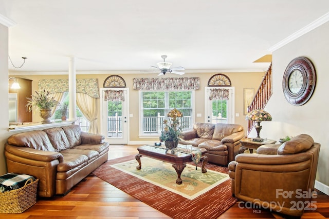 living room with crown molding, baseboards, ceiling fan, and wood finished floors