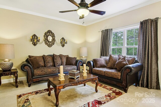 carpeted living area with crown molding, baseboards, and ceiling fan