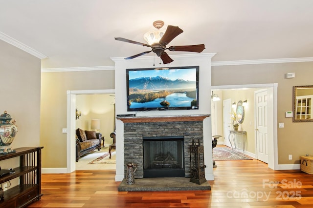 living room featuring crown molding, a ceiling fan, baseboards, and wood finished floors