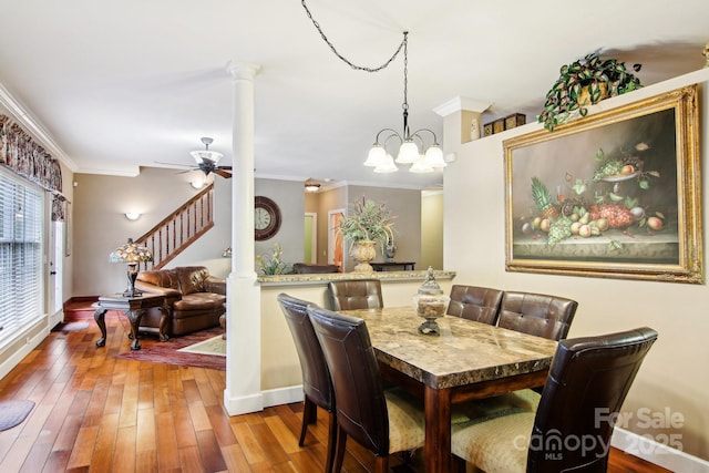 dining room with baseboards, decorative columns, ornamental molding, and wood finished floors