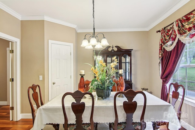 dining area with crown molding, baseboards, wood finished floors, and a notable chandelier