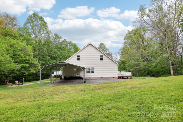 view of side of property featuring a lawn, a carport, and crawl space