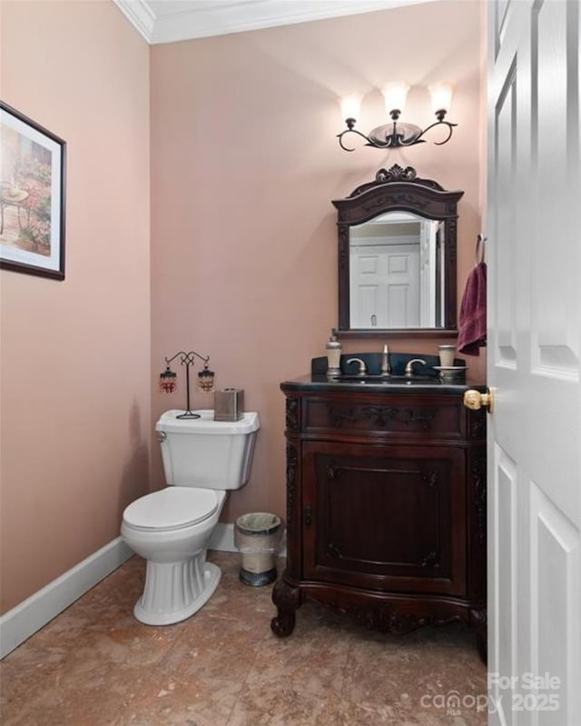 bathroom featuring crown molding, baseboards, toilet, and vanity