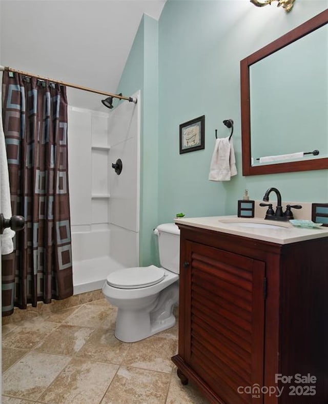full bath featuring vanity, lofted ceiling, toilet, a shower with shower curtain, and stone finish floor