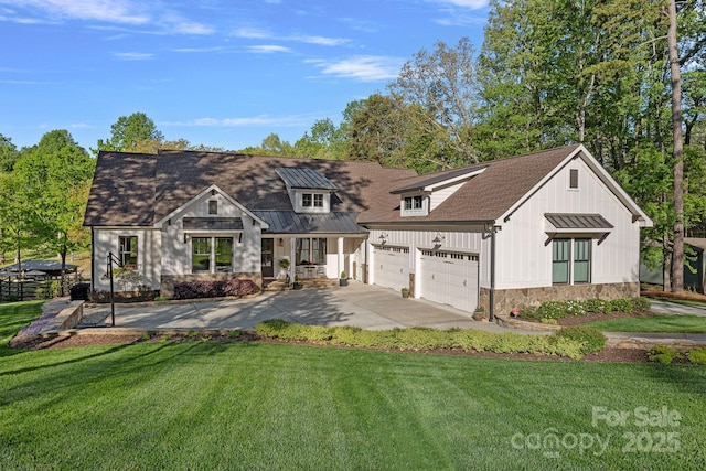view of front of home with a front lawn, concrete driveway, board and batten siding, an attached garage, and stone siding