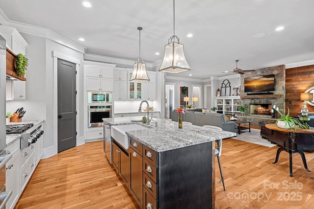 kitchen featuring recessed lighting, a kitchen breakfast bar, stainless steel appliances, a ceiling fan, and a sink