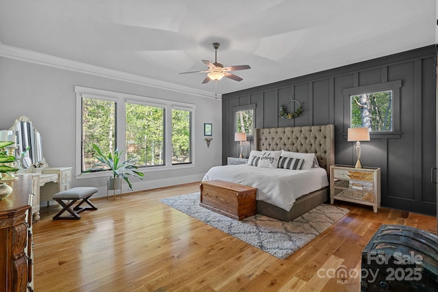 bedroom with ceiling fan, wood finished floors, and ornamental molding