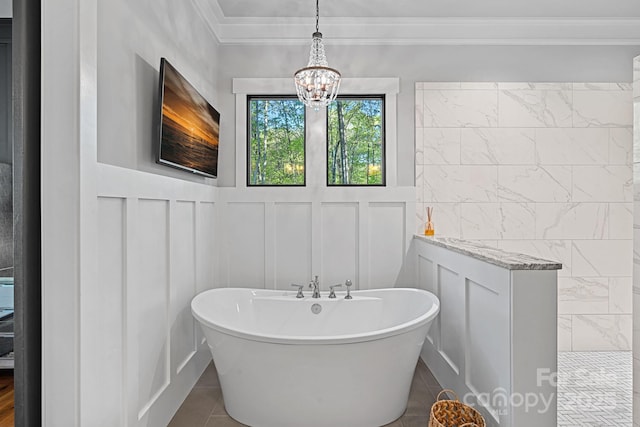bathroom with a notable chandelier, walk in shower, a freestanding tub, crown molding, and a decorative wall