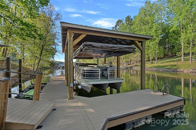 dock area with boat lift and a water view