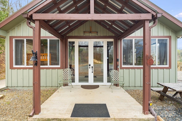 property entrance with board and batten siding, french doors, and a patio area