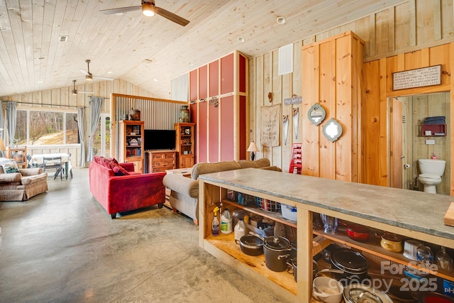 living room with wooden ceiling, vaulted ceiling, a ceiling fan, concrete flooring, and wooden walls