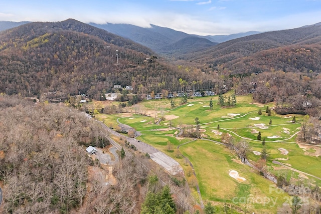 birds eye view of property with view of golf course, a mountain view, and a view of trees