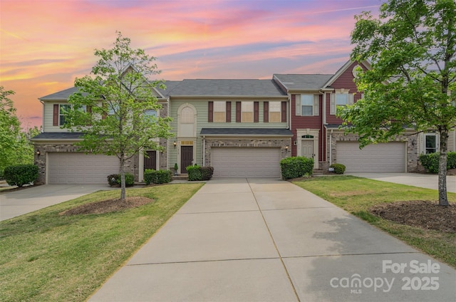 view of front of house with a lawn, driveway, and a garage