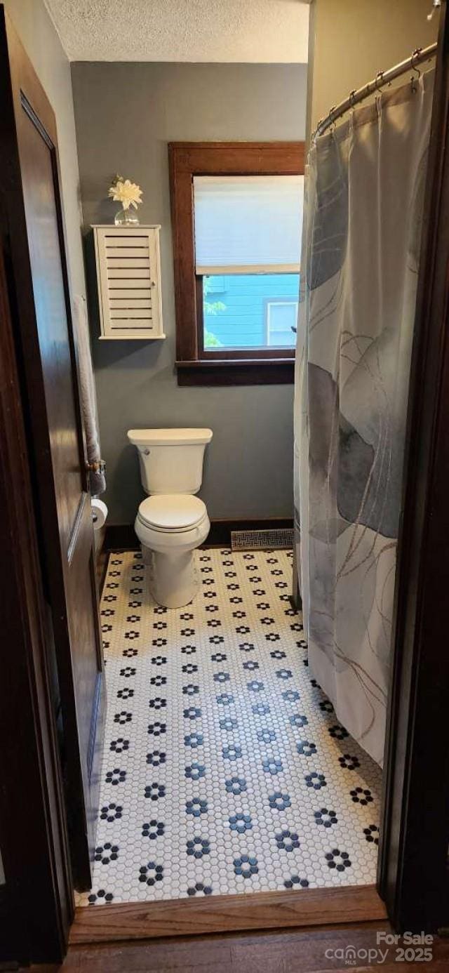 49 Euclid Blvd, Asheville, NC 28806 - full bath with toilet, a textured ceiling, a shower with curtain, and tile patterned floors