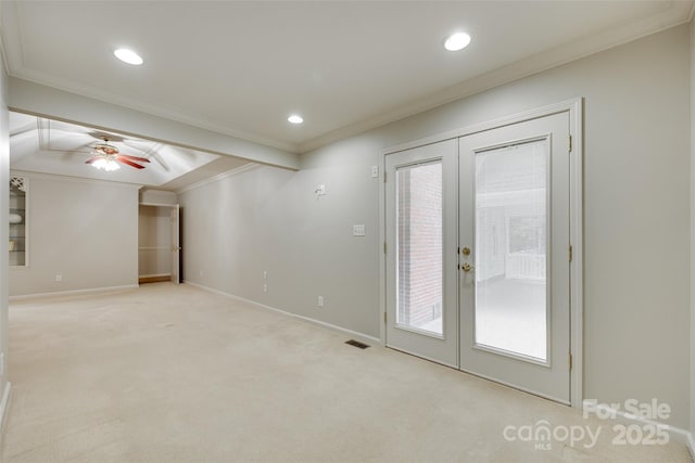 empty room featuring french doors, crown molding, light colored carpet, baseboards, and ceiling fan