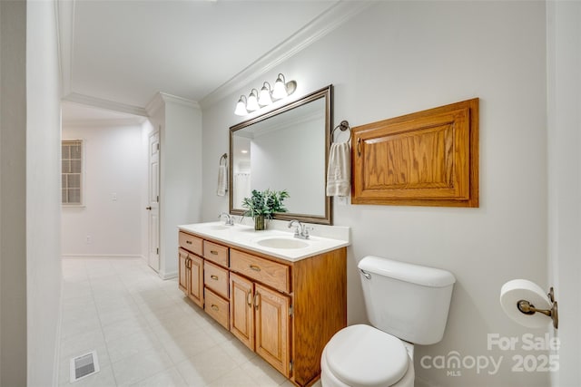 bathroom with toilet, ornamental molding, double vanity, and baseboards