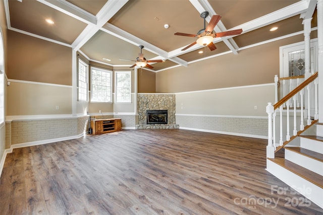 unfurnished living room featuring coffered ceiling, a ceiling fan, wainscoting, wood finished floors, and beam ceiling
