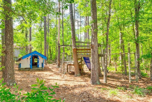 view of playground featuring a shed and an outbuilding