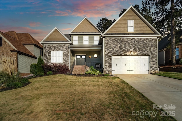 view of front facade featuring stone siding, an attached garage, a front yard, and concrete driveway