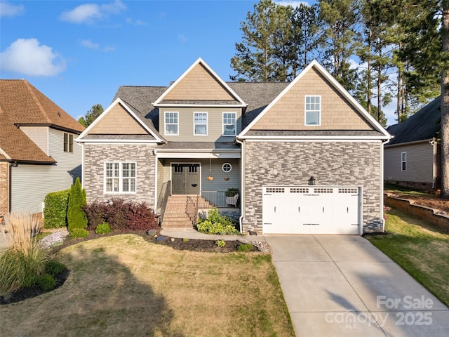 craftsman inspired home with stone siding, a front lawn, driveway, and a garage