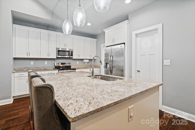 kitchen with recessed lighting, appliances with stainless steel finishes, baseboards, and a sink