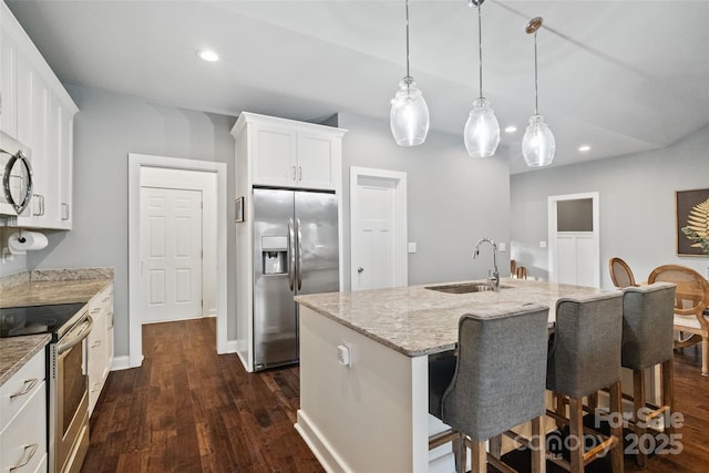 kitchen featuring recessed lighting, stainless steel appliances, a sink, light stone countertops, and dark wood-style flooring