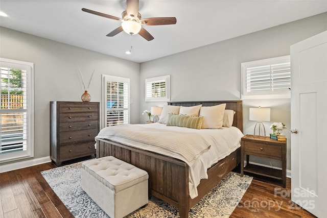 bedroom featuring baseboards, wood finished floors, recessed lighting, and multiple windows