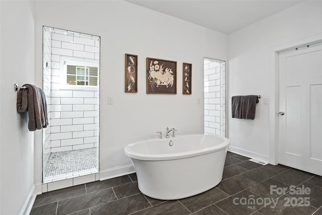 full bathroom with a freestanding bath, baseboards, tile patterned floors, and a stall shower