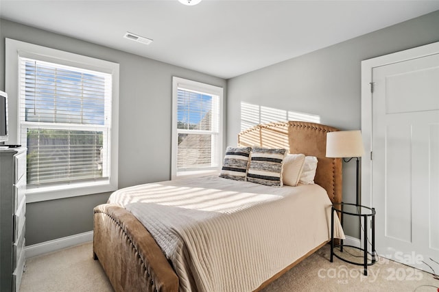 bedroom with baseboards, visible vents, and carpet
