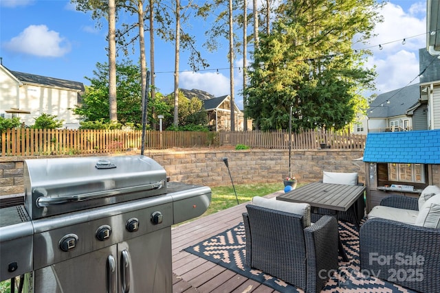 wooden terrace featuring a fenced backyard, an outdoor structure, and area for grilling