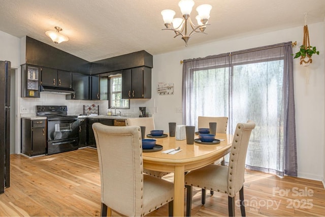 dining room with a notable chandelier and light wood finished floors