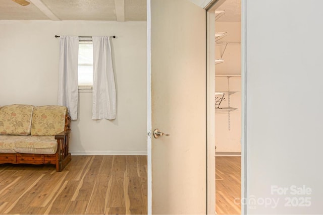 sitting room featuring baseboards and light wood-style floors