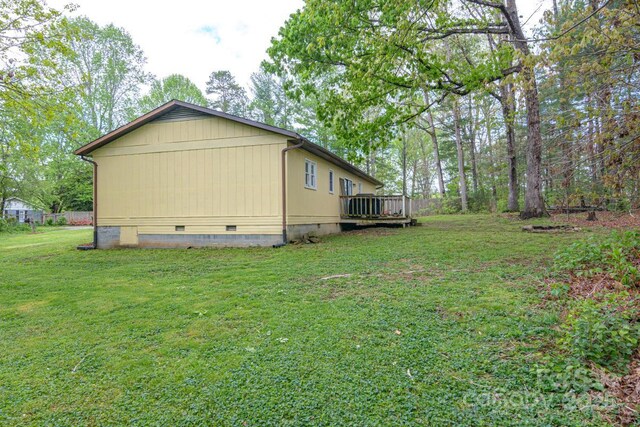 view of home's exterior featuring a lawn, a deck, and crawl space