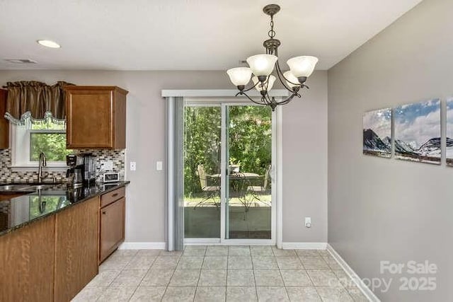 43 Sunny Meadows Blvd, Arden, NC 28704 - kitchen featuring a sink, a chandelier, brown cabinetry, backsplash, and decorative light fixtures
