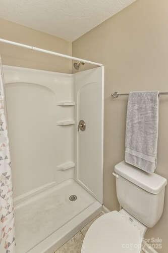 43 Sunny Meadows Blvd, Arden, NC 28704 - full bath featuring a stall shower, toilet, and tile patterned floors
