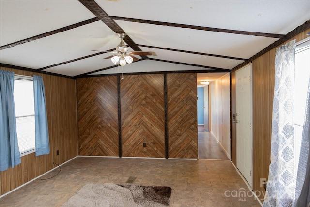 unfurnished room featuring vaulted ceiling with beams, wood walls, and ceiling fan