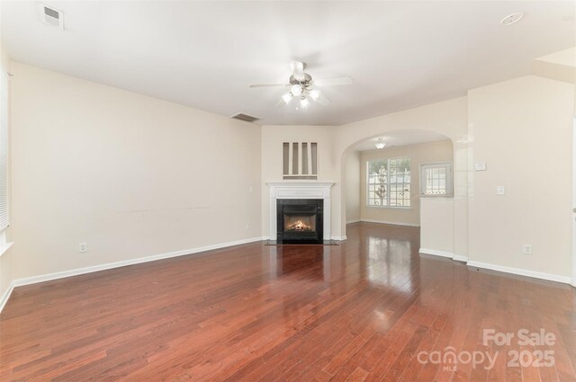 827 Gentlewinds Ct, Fort Mill, SC 29708 - unfurnished living room featuring visible vents, arched walkways, ceiling fan, and wood finished floors