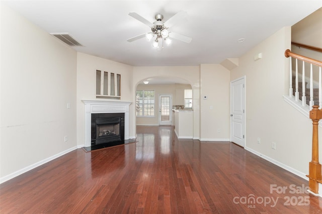 827 Gentlewinds Ct, Fort Mill, SC 29708 - unfurnished living room with a ceiling fan, arched walkways, a fireplace, wood finished floors, and stairway
