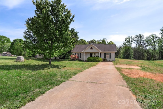 view of front of house with concrete driveway and a front lawn