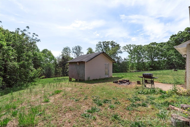 view of yard with an outdoor fire pit, an outdoor structure, and a shed