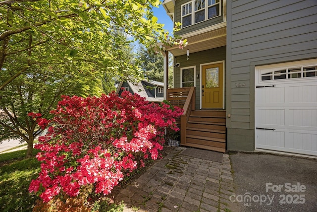 entrance to property featuring a garage and covered porch