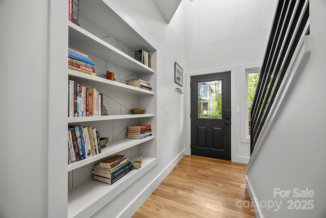 foyer featuring baseboards and light wood-style floors