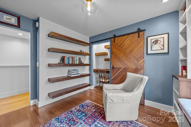 sitting room with baseboards, recessed lighting, and wood finished floors