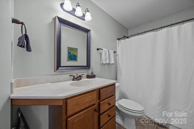 full bathroom with vanity, tile patterned floors, toilet, and a textured ceiling