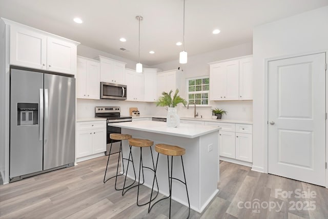 601 Westway Dr, Gastonia, NC 28054 - kitchen with a center island, white cabinetry, stainless steel appliances, and a kitchen breakfast bar