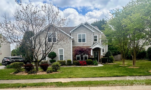 traditional-style house featuring fence, a front lawn, and stone siding